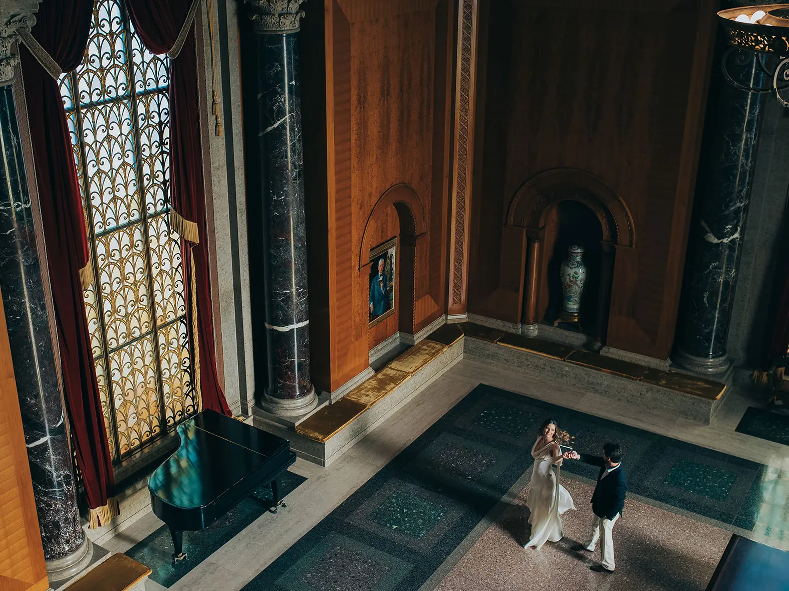 Wide view of Natalie and Spencer dancing beneath stained glass windows at the Armstrong Browning Library engagement session in Waco.