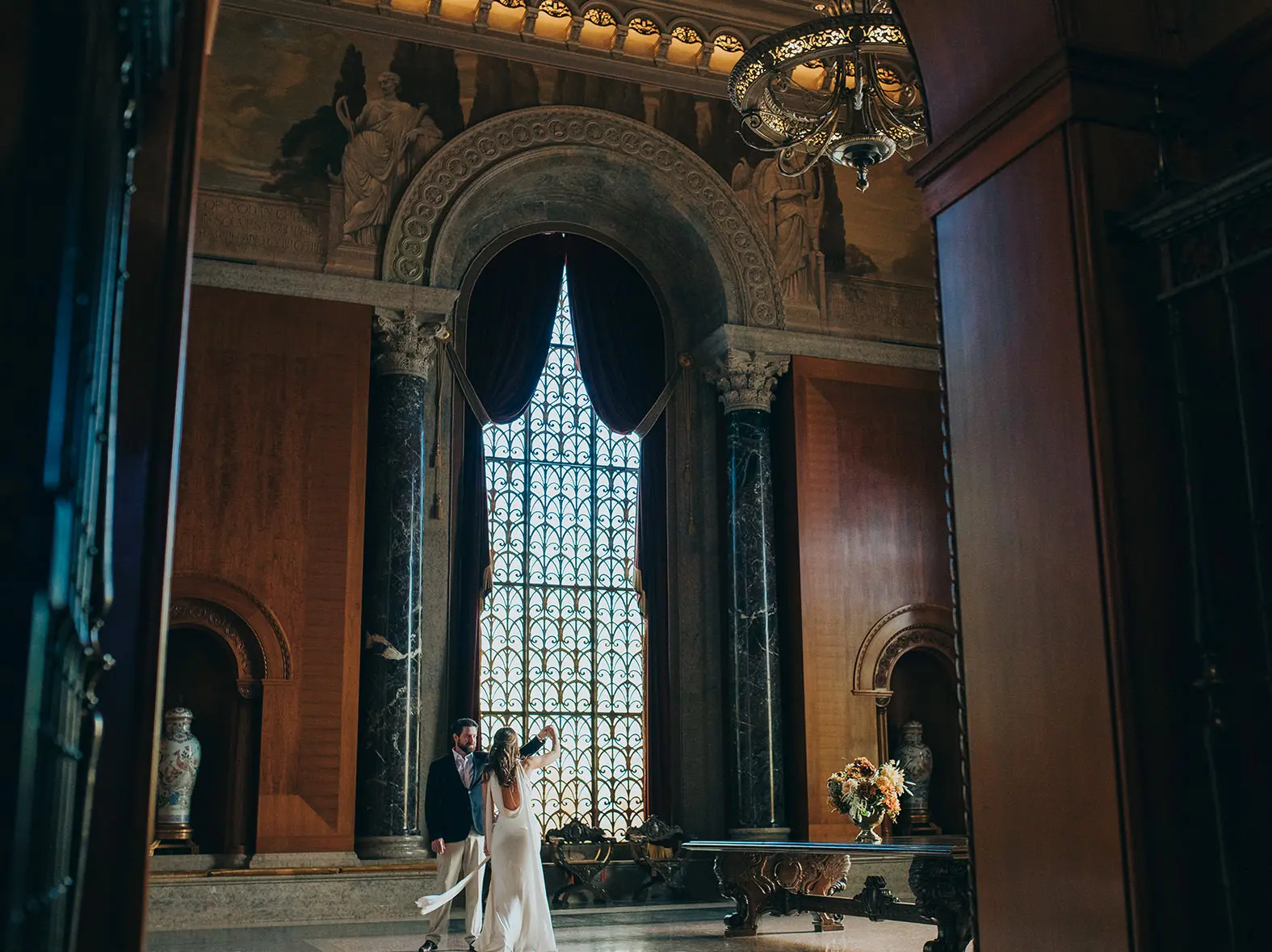 Grand interior view of the Armstrong Browning Library in Waco Texas with engaged couple framed by arched architecture.