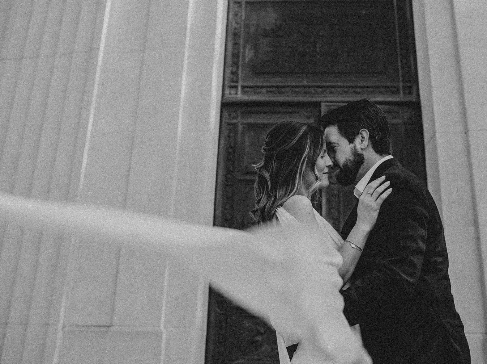 Black and white engagement photo of couple sharing a quiet moment outside the Armstrong Browning Library in Waco.
